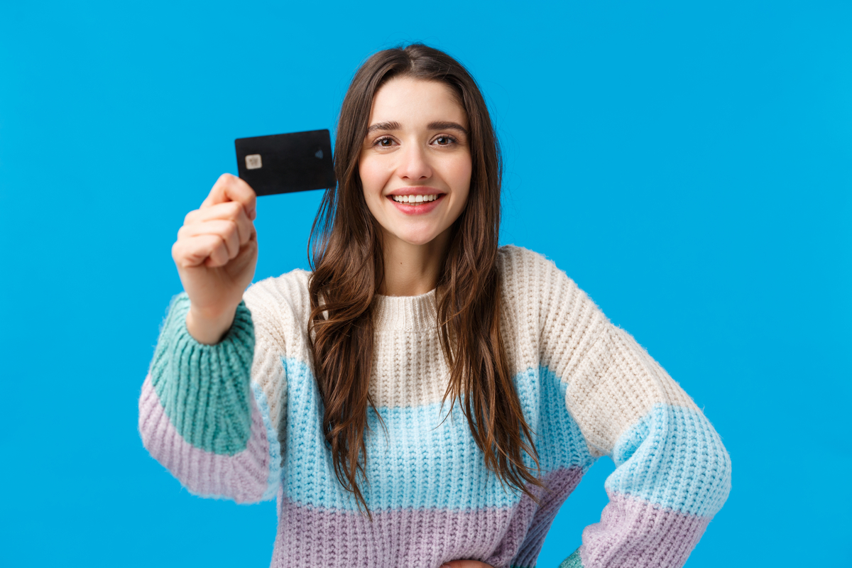 Woman holding up her favorite small business credit card.