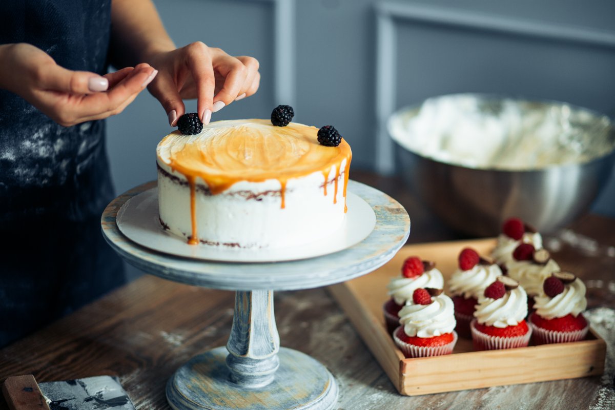 Close up on baker decorating cake