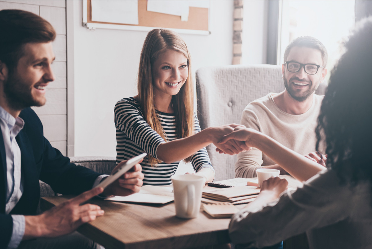 Group of businesspersons striking a deal.