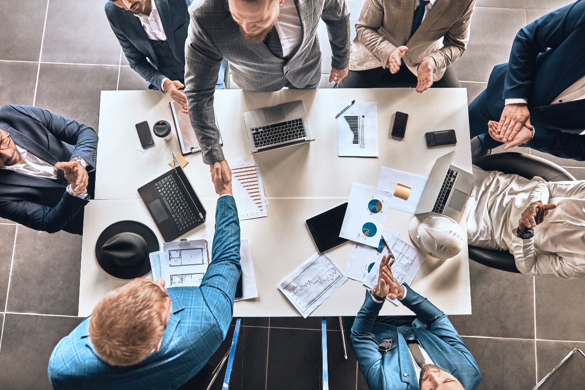 Group of professionals in a meeting shaking hands.