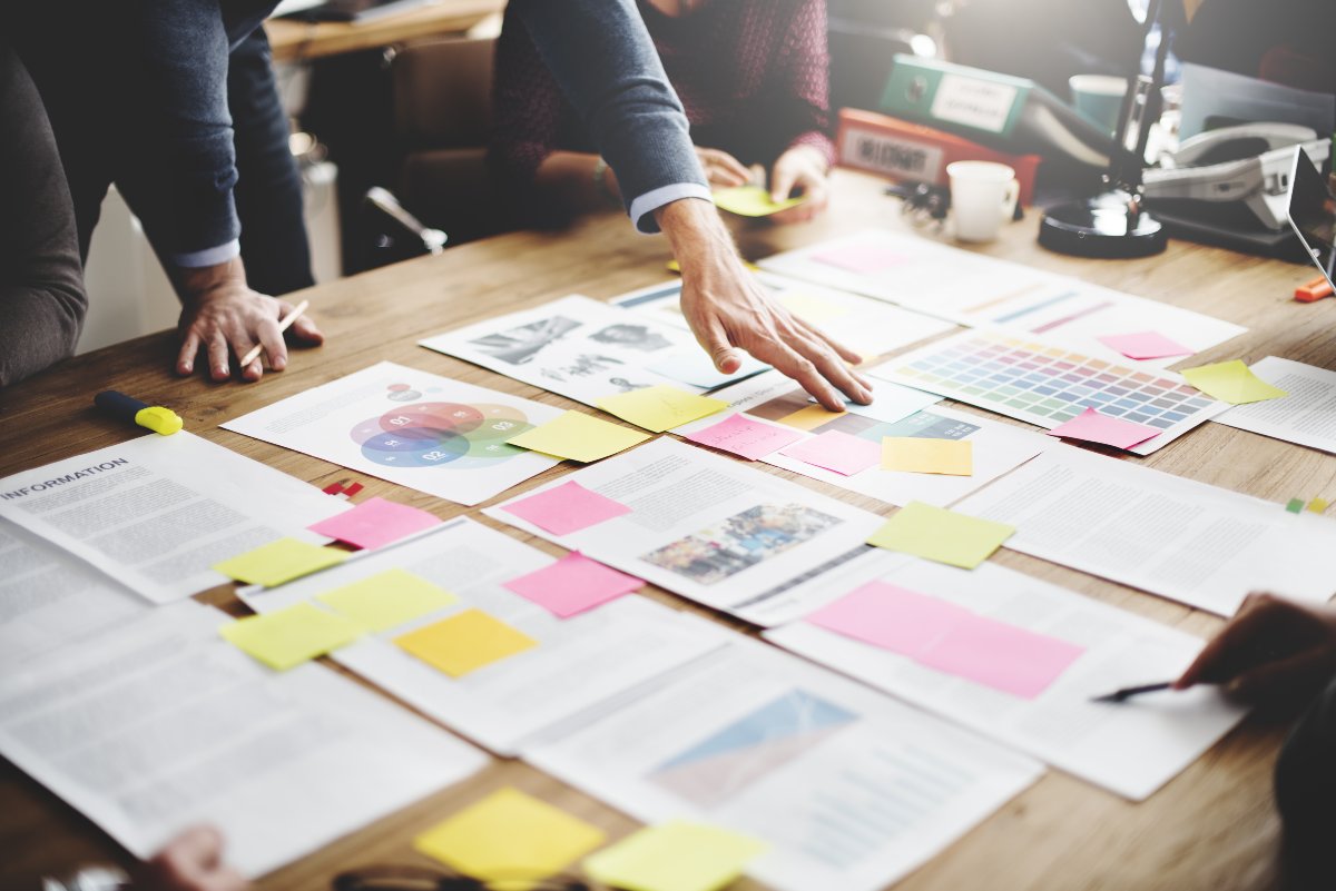 Professionals standing front of business planning materials.