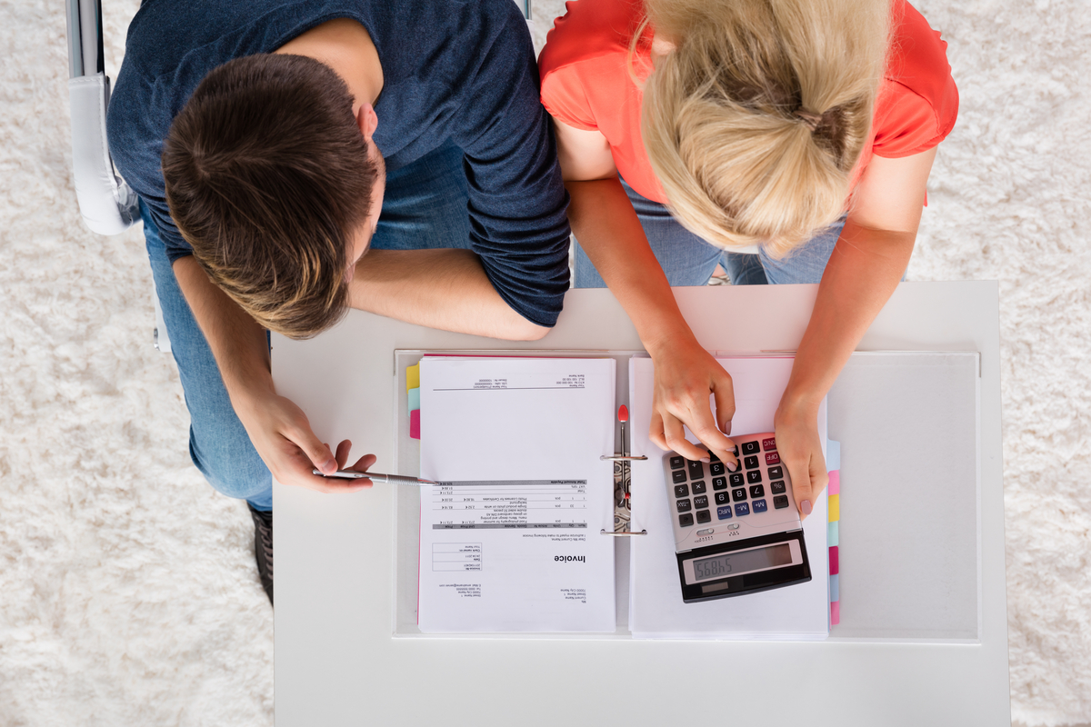 Man and woman calculating business debt on their computer.