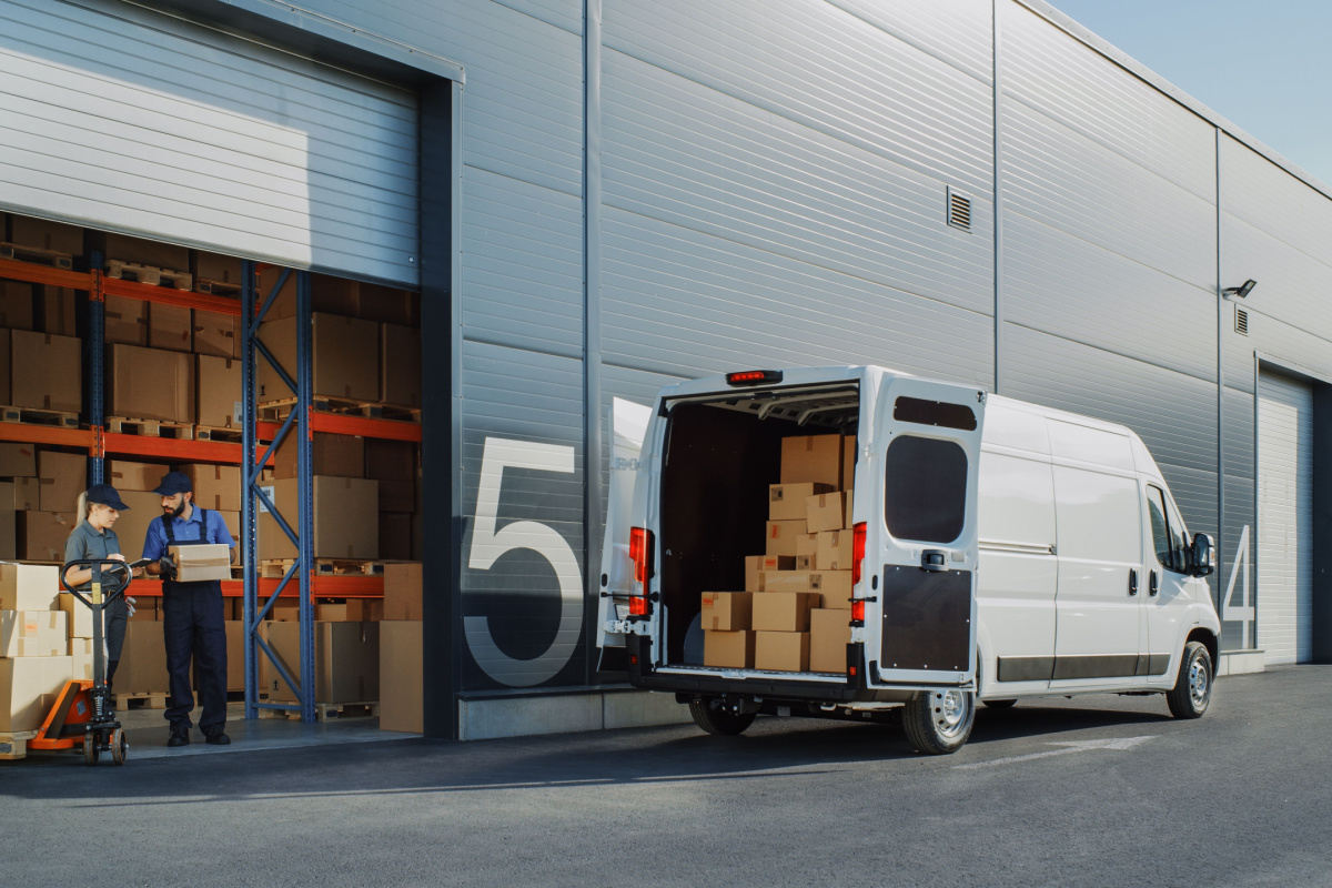Courier filling van at warehouse