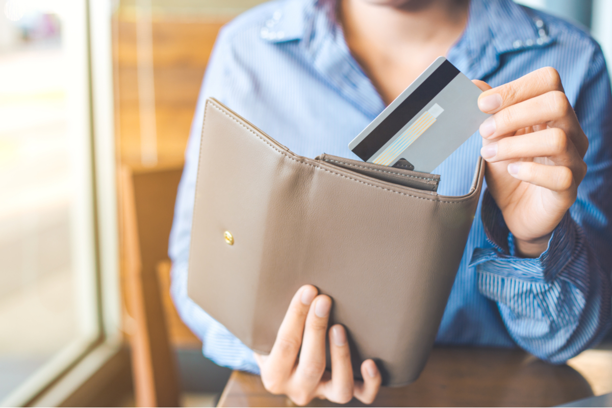 Woman pulling a credit card out of her wallet.