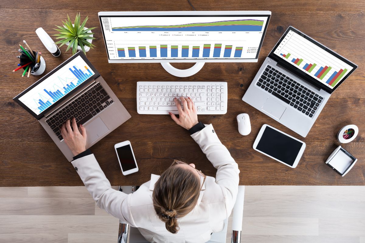 Overhead view of digital marketer working on laptop and computer 