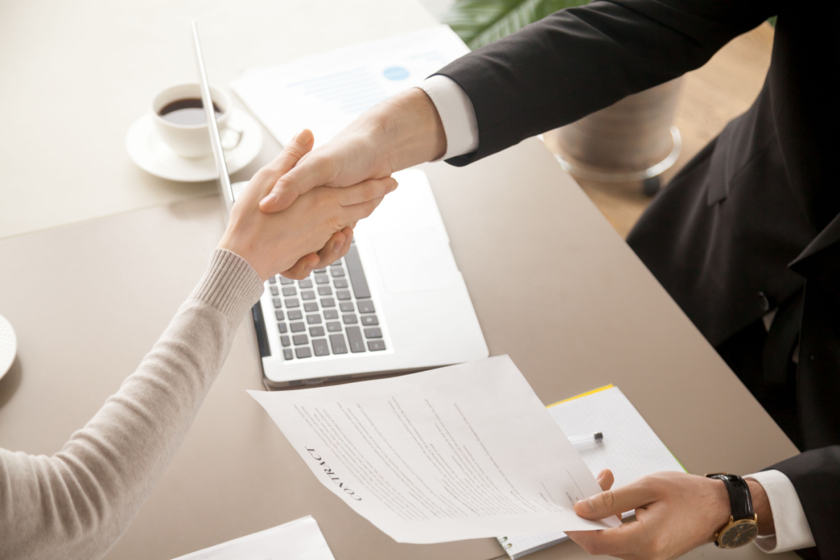 Franchisee and franchisor shaking hands over financing contract