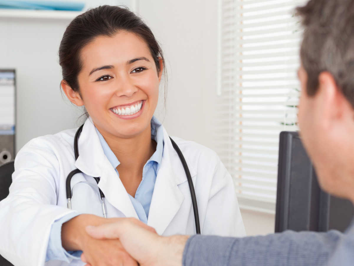 doctor shaking patient's hand and smiling
