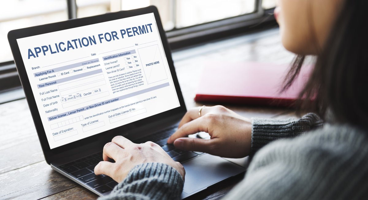 Small business owner applying for permits on laptop