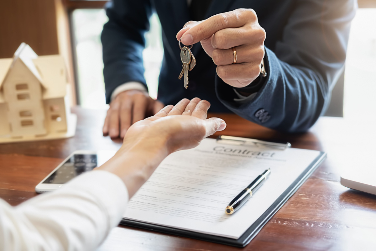 Real estate agent handing business owner keys and contract