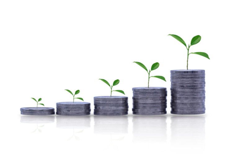 Tiny plants growing out of the tops of small stacks of change.