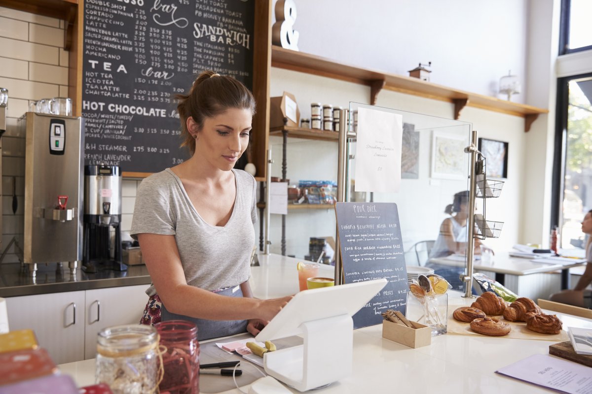 Employee using register at small business.