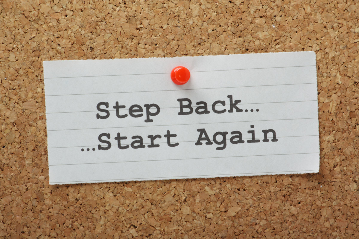 A sticky note with the words "Step back, start again" written on it. 