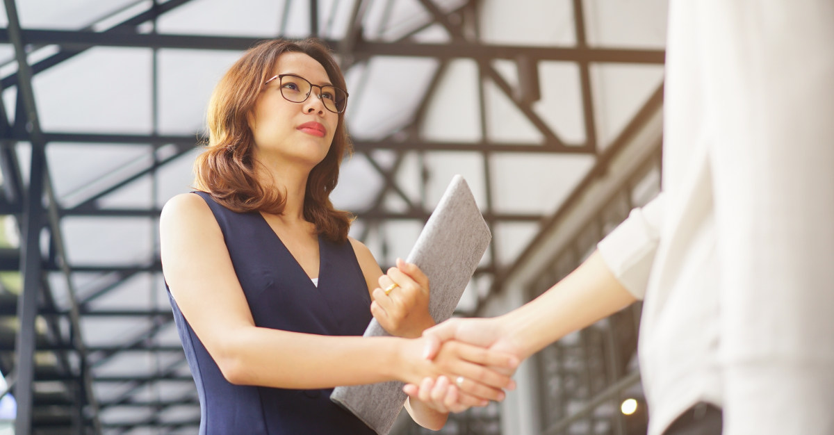 Woman shaking hands with business associate.