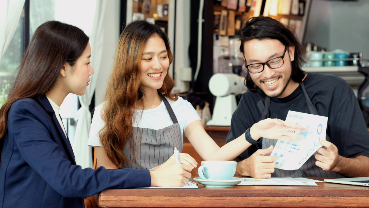 Small business owners discussing their finances with a financial planner.