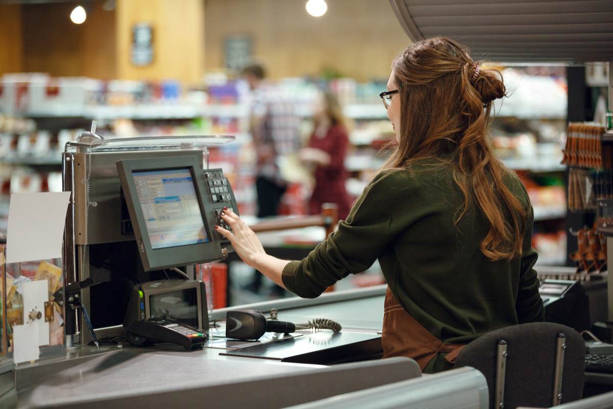Woman using a cash register at a store.