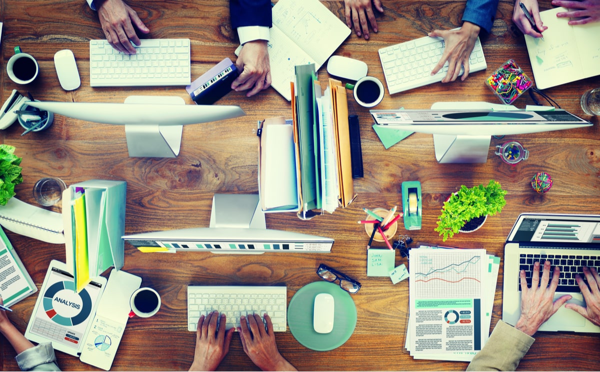 Open office with startup employees working on laptops and desktops.